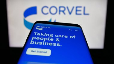 Stuttgart, Almanya - 11-27-2025: ABD 'li risk yönetimi şirketi CorVel Corporation' ın web sitesi bulunan cep telefonu logonun önünde ekranda. Telefon ekranının sol üst kısmına odaklan.