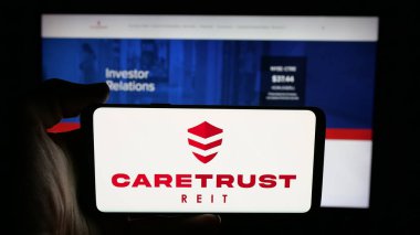 Stuttgart, Almanya - 11-27-2025: ABD 'li emlak şirketi CareTrust REIT Inc.' in logosunun bulunduğu cep telefonu web sayfasının önünde ekranda. Telefon ekranına odaklan.