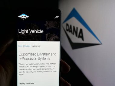 Stuttgart, Almanya - 11-28-2025: ABD 'li otomotiv şirketi Dana Anonim Şirketi' nin web sayfası ile akıllı telefon taşıyan kişi logonun önünde ekranda. Telefon ekranının merkezine odaklan.