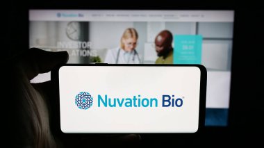 Stuttgart, Almanya - 11-28-2025: ABD 'li onkoloji şirketi Nuvation Bio Inc.' in logosunun bulunduğu cep telefonu web sayfasının önünde ekranda. Telefon ekranına odaklan.