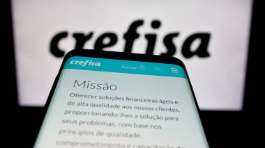Stuttgart, Almanya - 11-28-2025: Finans hizmetleri şirketi Banco Crefisa S.A. 'nın logolu akıllı telefon web sitesinin önünde ekranda. Telefon ekranının soluna odaklan.