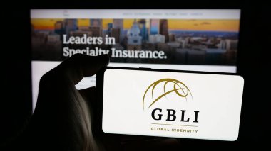 Stuttgart, Almanya - 11-28-2025: Web sayfası önünde ekranda Global Indemnity Group LLLC (GBLI) logosu bulunan cep telefonu sahibi kişi. Telefon ekranına odaklan.