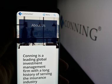 Stuttgart, Almanya - 11-28-2025: Yatırım şirketi Conning Holding Limited 'in web sayfası olan cep telefonu logosu önünde ekranda. Telefon ekranının merkezine odaklan.