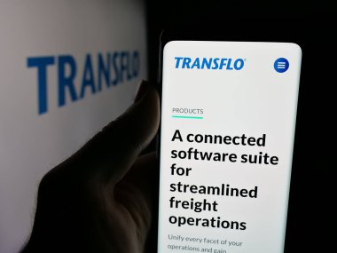Stuttgart, Almanya - 11-30-2025: ABD lojistik teknoloji şirketi Transflo 'nun web sitesi ile akıllı telefon sahibi kişi logo önünde ekranda. Telefon ekranının merkezine odaklan.