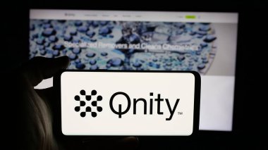 Stuttgart, Almanya - 12-01-2025: Web sayfası önünde ekranda ABD 'li teknoloji şirketi Qnity Electronics Inc.' in logosuyla cep telefonu tutan kişi. Telefon ekranına odaklan.