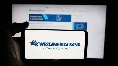 Stuttgart, Almanya - 12-01-2025: Finans hizmetleri şirketi Westamerica Bank 'ın logosunun bulunduğu cep telefonu web sayfası önünde ekranda. Telefon ekranına odaklan.