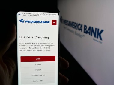 Stuttgart, Almanya - 12-01-2025: Finans hizmetleri şirketi Westamerica Bank 'ın web sayfası olan cep telefonu logosu önünde ekranda. Telefon ekranının merkezine odaklan.