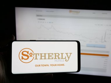 Stuttgart, Almanya - 12-02-2025: ABD 'li konukseverlik şirketi Sotherly Hotels Inc.' in logosunu elinde tutan kişi web sitesinin önünde ekranda. Telefon ekranına odaklan.