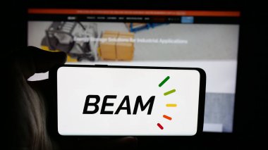 Stuttgart, Almanya - 12-02-2025: Web sayfası önünde ekranda ABD 'li EV şarj şirketi Beam Global' in logosuna sahip cep telefonu tutan kişi. Telefon ekranına odaklan.
