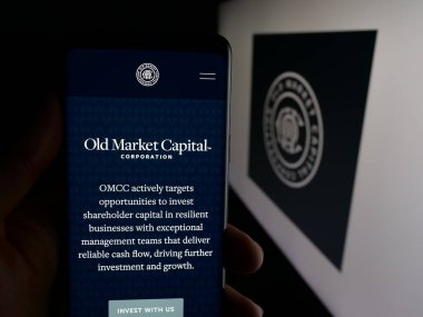 Stuttgart, Almanya - 12-02-2025: Old Market Capital Corporation şirketinin web sayfası logo önünde ekranda. Telefon ekranının merkezine odaklan.