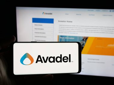 Stuttgart, Almanya - 12-02-2025: İrlandalı Avadel Pharmaceuticals plc şirketinin logosunu elinde tutan kişi web sitesinin önünde ekranda. Telefon ekranına odaklan.