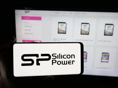 Stuttgart, Almanya - 12-02-2025: Web sitesinin önünde üzerinde Silikon Power Communications Inc. 'in logosu olan akıllı telefonu tutan kişi. Telefon ekranına odaklan.