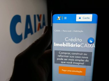 Stuttgart, Almanya - 12-02-2025: Brezilyalı Caixa Economica Federal 'in (CEF) web sayfası logonun önünde duran kişi. Telefon ekranının merkezine odaklan.