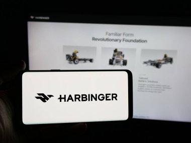 Stuttgart, Almanya - 12-03-2025: ABD 'li otomotiv şirketi Harbinger Motors Inc.' in logosunu taşıyan kişi web sitesinin önünde ekranda. Telefon ekranına odaklan.