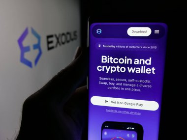 Stuttgart, Almanya - 12-03-2025: ABD 'li şifreleme şirketi Exodus Movement Inc.' in web sayfası ile akıllı telefon sahibi kişi logo önünde ekranda. Telefon ekranının merkezine odaklan.