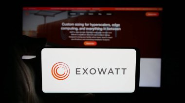 Stuttgart, Almanya - 12-03-2025: Web sayfasının önünde üzerinde ABD 'li yenilenebilir enerji şirketi Exowatt Inc.' in logosu olan cep telefonu bulunan kişi. Telefon ekranına odaklan.
