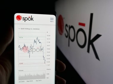 Stuttgart, Almanya - 12-05-2025: ABD 'li iletişim şirketi Spok Holding Inc.' nin web sayfası ile akıllı telefon sahibi kişi logonun önünde ekranda. Telefon ekranının merkezine odaklan.