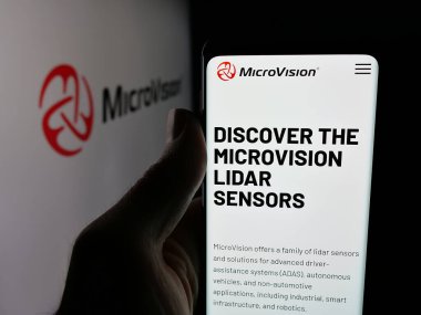 Stuttgart, Almanya - 12-05-2025: ABD 'li teknoloji şirketi MicroVision Inc.' in web sayfası ile akıllı telefonu olan kişi logonun önünde ekranda. Telefon ekranının merkezine odaklan.