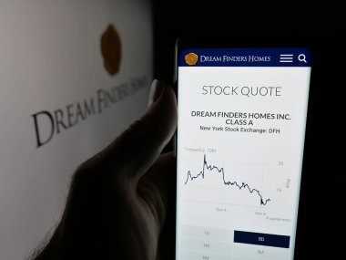 Stuttgart, Almanya - 12-08-2025: Ev yapım şirketi Dream Finders Homes Inc. 'in web sayfasını elinde tutan kişi logonun önünde ekranda. Telefon ekranının merkezine odaklan.