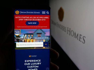 Stuttgart, Almanya - 12-08-2025: Ev yapım şirketi Dream Finders Inc. 'in web sayfası olan cep telefonu logonun önünde ekranda. Telefon ekranının merkezine odaklan.