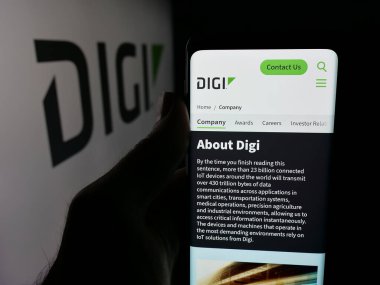 Stuttgart, Almanya - 12-08-2025: ABD 'li IIoT şirketi Digi International Inc.' in web sayfası ile akıllı telefon sahibi kişi logonun önünde ekranda. Telefon ekranının merkezine odaklan.