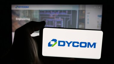 Stuttgart, Almanya - 12-10-2025: ABD 'li sözleşmeli şirket Dycom Industries Inc.' in logosunu taşıyan cep telefonu web sayfasının önünde ekranda. Telefon ekranına odaklan.