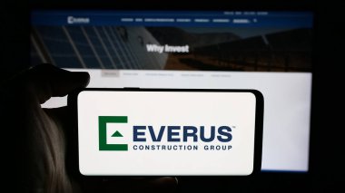 Stuttgart, Almanya - 12-10-2025: ABD 'li Everus İnşaat Grubu Inc. şirketinin logosunun bulunduğu cep telefonu web sayfası önünde ekranda. Telefon ekranına odaklan.