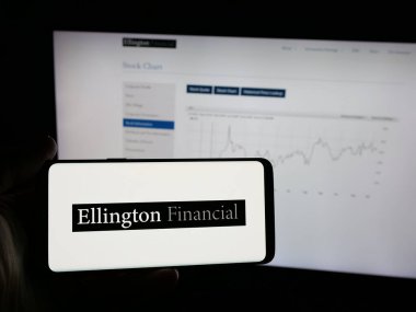 Stuttgart, Almanya - 12-10-2025: ABD 'li mortgage şirketi Ellington Financial Inc.' in logosunu elinde tutan kişi web sitesinin önünde ekranda. Telefon ekranına odaklan.