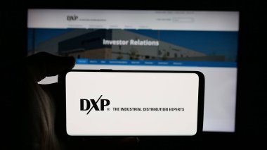 Stuttgart, Almanya - 12-10-2025: ABD 'li dağıtım şirketi DXP Enterprises Inc.' in logosunun bulunduğu cep telefonu web sayfasının önünde ekranda. Telefon ekranına odaklan.