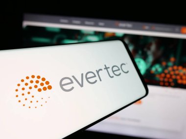 Stuttgart, Almanya - 12-10-2025: Web sitesi önünde ekranda finans teknolojisi şirketi Evertec Inc. 'in logosuna sahip akıllı telefon. Telefon ekranının merkez soluna odaklan.
