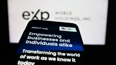 Stuttgart, Almanya - 12-10-2025: Emlak şirketi eXp World Holding Inc. 'nin web sitesi olan cep telefonu logonun önünde ekranda. Telefon ekranının sol üst kısmına odaklan.