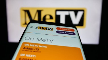 Stuttgart, Almanya - 12-11-2025: Amerikan televizyon kanalı MeTV 'nin web sitesinin bulunduğu cep telefonu logonun önünde ekranda. Telefon ekranının sol üst kısmına odaklan.