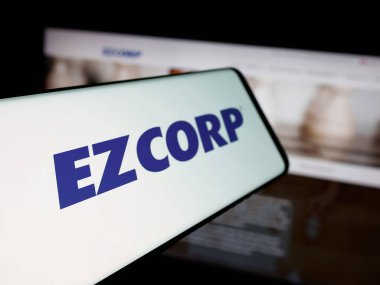 Stuttgart, Almanya - 12-11-2025: Web sitesinin önünde ekranda EZCORP Inc. 'in logosuna sahip akıllı telefon. Telefon ekranının soluna odaklan.
