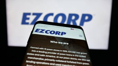 Stuttgart, Almanya - 12-11-2025: ABD 'li rehin dükkanı şirketi EZCORP Inc.' in web sitesi ile birlikte cep telefonu logonun önünde ekranda. Telefon ekranının sol üst kısmına odaklan.
