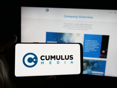 Stuttgart, Almanya - 12-12-2025: ABD 'li yayın şirketi Cumulus Media Inc.' in logosuna sahip kişi web sitesinin önünde ekranda. Telefon ekranına odaklan.