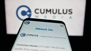 Stuttgart, Almanya - 12-12-2025: ABD 'li yayın şirketi Cumulus Media Inc.' nin web sitesiyle birlikte cep telefonu logonun önünde ekranda. Telefon ekranının sol üst kısmına odaklan.