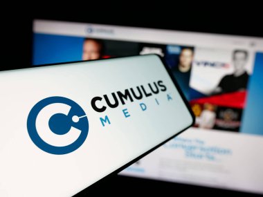 Stuttgart, Almanya - 12-12-2025: İnternet sitesi önünde ekranda ABD 'li yayın şirketi Cumulus Media Inc.' in logosuna sahip akıllı telefon. Telefon ekranının merkez soluna odaklan.