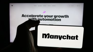 Stuttgart, Almanya - 12-12-2025: İnternet sayfasının önünde ABD 'li sohbet pazarlama şirketi Manychat Inc.' in logosuyla cep telefonu tutan kişi. Telefon ekranına odaklan.