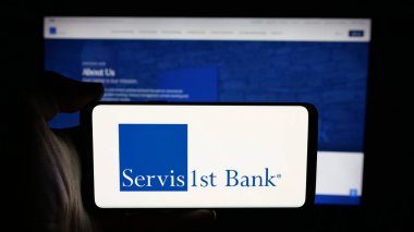 Stuttgart, Almanya - 12-12-2025: Web sayfası önünde ekranda ABD Bankası ServisFirst Bancshare Inc. logosunun logosu olan kişi. Telefon ekranına odaklan.