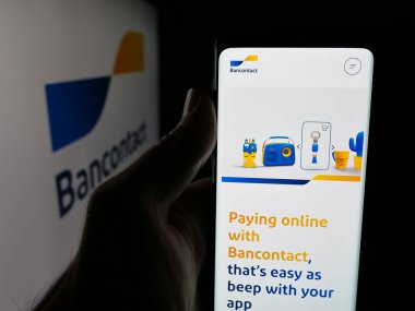 Stuttgart, Almanya - 12-16-2025: Belçikalı finans hizmetleri şirketi Bancontact 'in internet sayfası ile akıllı telefon sahibi kişi logonun önünde ekranda. Telefon ekranının merkezine odaklan.