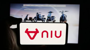 Stuttgart, Almanya - 12-17-2025: Web sayfası önünde ekranda elektrikli scooter şirketi Niu Technologies 'in logosunun bulunduğu cep telefonu sahibi kişi. Telefon ekranına odaklan.