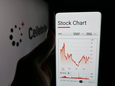 Stuttgart, Almanya - 12-17-2025: Dijital adli tıp şirketi Cellebrite DI Ltd. 'nin internet sayfası ile cep telefonunu logo önünde ekranda tutan kişi. Telefon ekranının merkezine odaklan.
