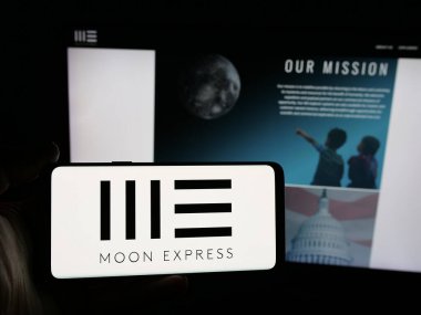 Stuttgart, Almanya - 12-17-2025: ABD 'li uzay şirketi Moon Express Inc.' in logosuna sahip akıllı telefon sahibi kişi web sitesinin önünde ekranda. Telefon ekranına odaklan.