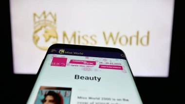 Stuttgart, Almanya - 12-18-2025: Güzellik yarışması organizasyonu Miss World 'ün web sitesi bulunan cep telefonu logonun önünde ekranda. Telefon ekranının sol üst kısmına odaklan.