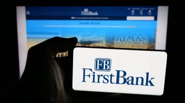 Stuttgart, Almanya - 12-18-2025: Web sayfası önünde ekranda ABD 'li FB Financial Corp (FirstBank) şirketinin logosunun bulunduğu cep telefonu sahibi kişi. Telefon ekranına odaklan.