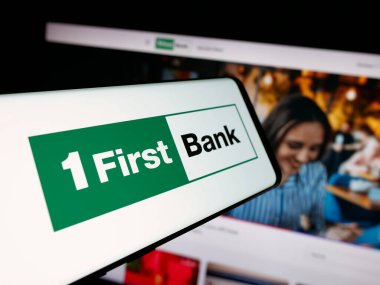 Stuttgart, Almanya - 12-18-2025: Finans şirketi First Bancorp 'un (FirstBank) logosuna sahip akıllı telefon web sitesinin önünde ekranda. Telefon ekranının merkezine odaklan.