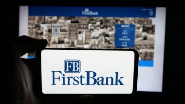 Stuttgart, Almanya - 12-18-2025: Web sayfası önünde ABD 'li FB Financial Corp. (FirstBank) şirketinin logosunun bulunduğu cep telefonu sahibi kişi. Telefon ekranına odaklan.