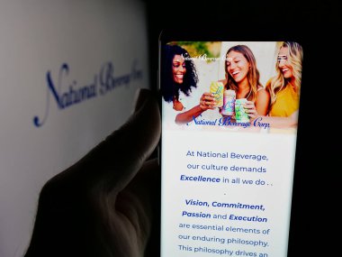 Stuttgart, Almanya - 12-18-2025: ABD 'li içecek şirketi National Beverage Corp' un web sayfası ile akıllı telefon sahibi kişi logonun önünde ekranda. Telefon ekranının merkezine odaklan.