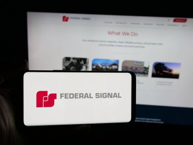 Stuttgart, Almanya - 12-18-2025: ABD 'li Federal Sinyal Şirketi' nin logosunu taşıyan kişi web sitesinin önünde ekranda. Telefon ekranına odaklan.