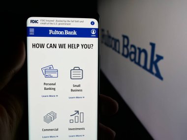 Stuttgart, Almanya - 12-19-2025: Bankacılık şirketi Fulton Financial Corporation 'ın web sayfası ile akıllı telefonu olan kişi logonun önünde ekranda. Telefon ekranının merkezine odaklan.